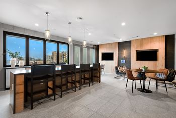 A modern dining room with a long table and chairs.